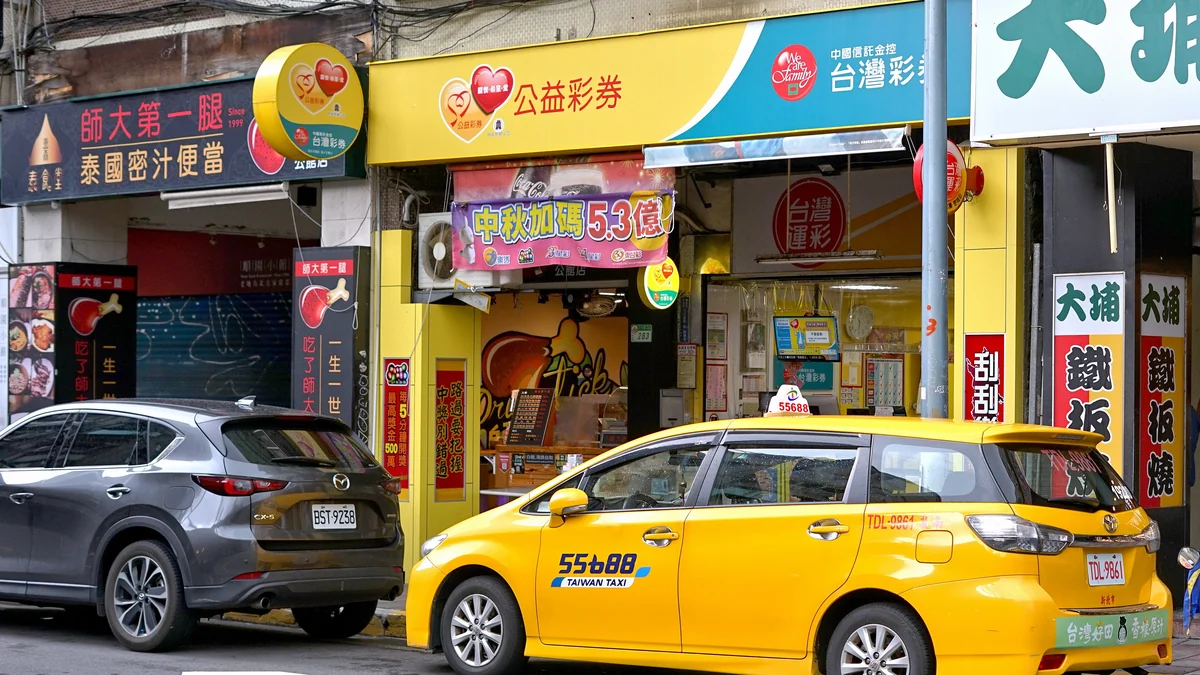 今彩539 投注站實拍:中國信託・台灣彩券公益彩券門市,掛著公益彩券、台灣運彩招牌與『中獎別錯過』刮刮樂布條——今彩539天天開獎,這種店就是買號、對獎、抄下開獎號碼畫版路的第一線(圖:Wikimedia Commons,CC BY-SA 4.0,2024年攝)